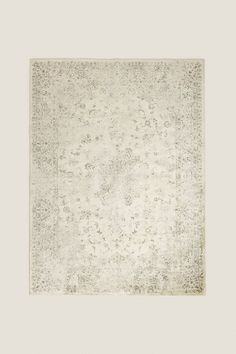 an antique rug with white and grey colors