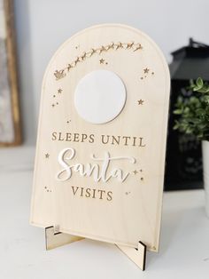 a wooden sign that says sleep until santa visit's with stars and moon on it