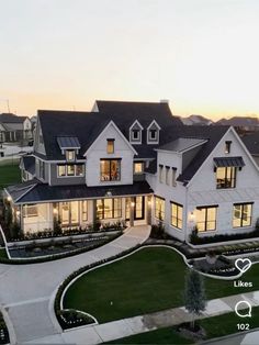 a large white house with lots of windows and lights on it's front lawn