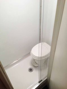 a white toilet sitting in a bathroom next to a shower