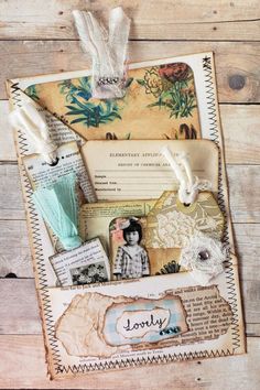 an altered collage with paper, tags and other items on a wooden table top