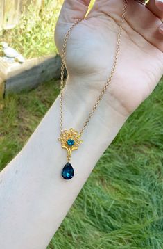 This is one of the beautiful necklaces that Kate wears in season 2. It reminds me of a peacock with the shape and teal blue colors. It is made with a gold tone filigree that has a teal blue rhinestone set into the center. Another teal blue drop rhinestone hangs from the bottom. Choose your preferred length, as shown it is 16 inches. This lovely piece makes a great gift for a loved one or yourself. Blue Brass Jewelry For Wedding, Elegant Peacock Pendant Necklace, Handmade Peacock Colored Jewelry For Weddings, Elegant Peacock Color Pendant Necklace, Handmade Peacock Wedding Jewelry, Ornate Peacock Design Necklace For Gift, Elegant Blue Peacock Design Jewelry, Blue Filigree Necklace For Wedding, Elegant Blue Brass Necklace