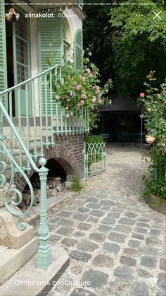 an old house with green shutters and stone steps