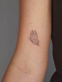 a woman's arm with a small butterfly tattoo on the back of her left arm