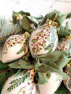 christmas ornaments with green ribbons and bows on them