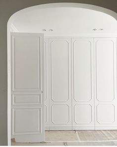 an arched doorway leading into a white room