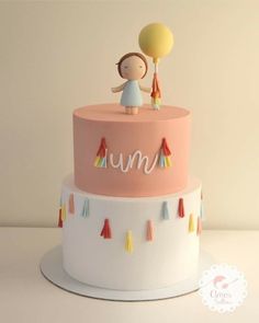 there is a cake that has a girl on top with a balloon in the air