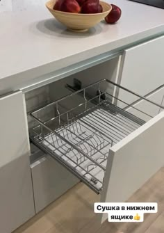 a bowl of apples sitting on top of a counter next to a drawer that is open