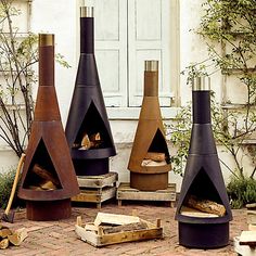 three different types of outdoor fireplaces sitting on the ground