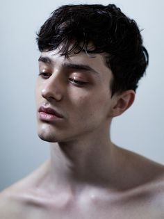 black and white photograph of a shirtless man with his eyes closed looking off to the side