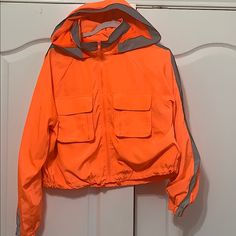 Orange Hooded Jacket With Silver Stripe Orange Hooded Outerwear For Outdoor Activities, Orange Outerwear With Pockets For Outdoor Activities, Sporty Orange Windbreaker For Fall, Orange Outerwear For Outdoor Activities In Fall, Orange Windbreaker With Pockets For Fall, Casual Orange Windbreaker For Outdoor, Orange Sporty Windbreaker For Fall, Sporty Orange Outerwear For Outdoor Activities, Hooded Orange Outerwear For Fall