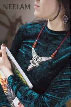 A beautiful and unique bohemian necklace in an eastern style, with deep carnelian and seed beads. This beautiful piece is closed with a toggle clasp. Three strands of black matte seed beads lead from it to the main piece - an angular metal plate, holding aother unusually shaped element - an oval merged with a triangle. There are three carnelian gemstones sitting down the middle of the necklace, framed by the curls and twigs of the metal embossing.This beautiful, elegant piece will look magnifice Bohemian Silver Beaded Necklaces With Carnelian, Metal Embossing, Carnelian Necklace, Bohemian Necklace, Metal Plate, Black Matte, Toggle Clasp, Bohemian Jewelry, Seed Beads