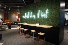 the interior of an office with green wall and bar stools in front of it