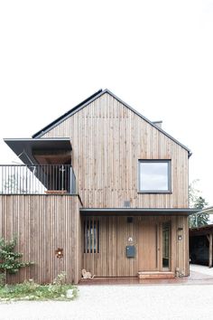 a large wooden house sitting on top of a gravel field