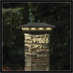 an outdoor light that is on top of a brick pillar