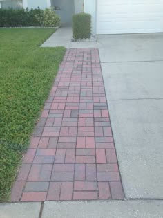 a red brick sidewalk in front of a white garage