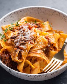 a white bowl filled with pasta and meat