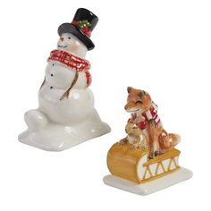 two ceramic figurines of dogs on sled with snowman and dog in top hat