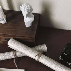 two pieces of paper are tied up on a table next to some books and pencils