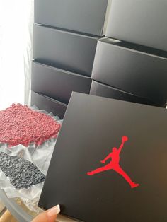 a person holding up a black box with a red air jordan sticker on it