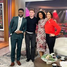 three people are standing in front of a television set and posing for the camera with their arms around each other