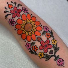 a woman's arm with flowers and hearts painted on the inside of her arm