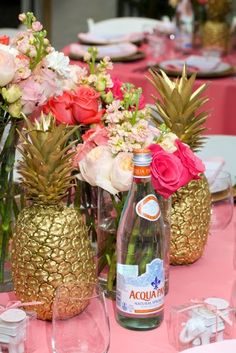 there are pineapples and flowers in vases on the table with wine glasses