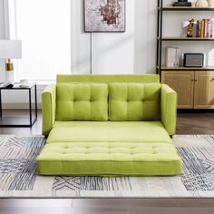 a green couch sitting on top of a rug in a living room