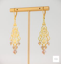 These unbelievably pretty Amber glass filigree dangle earrings are a stunning addition to any jewelry collection. The faceted amber glass beads are perfectly paired with the lovely gold-plated filigree and lever backs for a secure fit and luxurious look. Beautiful Amber and white colored glass beads. Gold-plated filigree. Gold-plated wire and lever backs. 2.75 inches long. These earrings are perfect for any occasion, from a night out to a special event. The unique design and beautiful amber glas Delicate Gold Chandelier Earrings For Party, Czech Glass Dangle Earrings For Wedding, Elegant Czech Glass Earrings For Party, Elegant Pierced Earrings With Czech Glass, Elegant Beaded Dangle Crystal Earrings, Elegant Czech Glass Earrings For Jewelry Making, Elegant Czech Glass Jewelry With Matching Earrings, Elegant Beaded Drop Earrings With Dangling Beads, Handmade Adjustable Elegant Chandelier Earrings