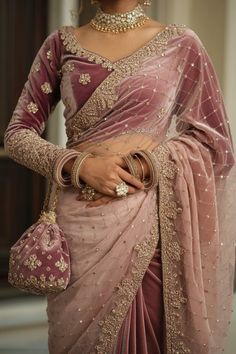 A photo of a Pakistani bride wearing a peach saree with a maroon velvet shawl-like blouse. The saree is made of soft peach lace fabric and is delicately detailed with floral lace. The maroon blouse has golden embroidered accents and features intricate golden beaded tassels on the sleeves. Indian Wedding Clothes Women, Maroon Saree With Golden Blouse, Saree For Sagai Function, Accessories On Saree, Velvet Saree Look, Maroon Sharara Suit, Net Saree Look, Saree For Reception Brides, Bridal Suits For Women