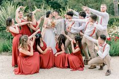 a group of people standing next to each other in front of plants and flowers on the ground