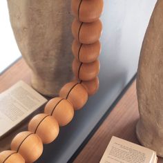 a wooden bead necklace sitting on top of a table next to an open book