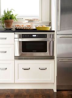 a kitchen with white cabinets and stainless steel appliances