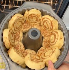 someone is holding a bundt cake in front of an oven