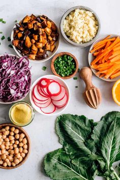 various vegetables are arranged in bowls on a table