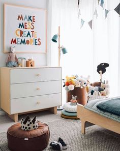 a child's bedroom with toys on the floor, and a poster above the bed