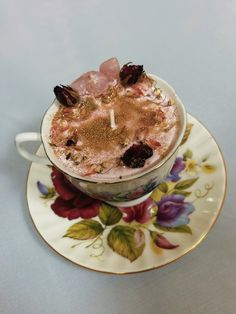 a cup filled with food on top of a saucer next to a flowered plate