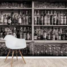 an old fashioned bar with liquor bottles and glasses on the shelves in black and white