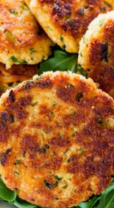 several crab cakes on a plate with greens