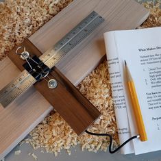 an open book with a ruler and pencil on top of it next to a pair of scissors