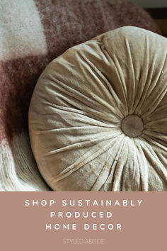 a round pillow sitting on top of a bed with the words shop sustainablely produced home decor