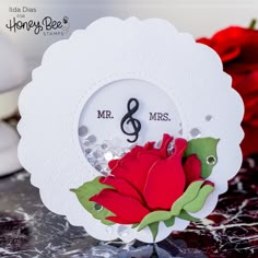 a close up of a card with a rose on it and a music note in the middle