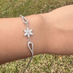 Daisy Diamond Flower Silver Charm Bracelet Anniversary Gift For Woman ⭐ All of our products are handmade and their materials are 925 sterling silver. ⭐ Bracelet lenght : 7.4'' (19 cm) ⭐ Bracelet weight : 3.69 gr ⭐ Materials: Silver ⭐ Nickel free hypoallergenic for sensitive skin. ⭐ Lightweight, perfect for everyday wear. ⭐ All of our products are handcrafted and ± 5% deviation may occur in grams and sizes. ⭐ If you have any question, contact us freely. ⭐ The light color of the photos may vary on computer and phone.      --- Care Guide --- * Unfortunately, 925 sterling and all other silver types tarnish in time. So the question is; How can we slow it down? * Contact with water: Not a great idea. But, it is unlikely to do any lasting damage. Just make sure to dry it after. * Swimming Pool: C Flower-shaped Cubic Zirconia Bracelets As Gift, Flower Shaped Crystal Bracelet Gift, Adjustable Flower Bracelets For Formal Occasions, Formal Adjustable Flower Bracelets, Elegant Silver Bracelets With Flower Shape, Elegant Sterling Silver Flower Bracelets, Elegant Silver Bracelets In Flower Shape, Elegant Silver Flower-shaped Bracelets, Silver Sterling Silver Bracelets With Flower Shape