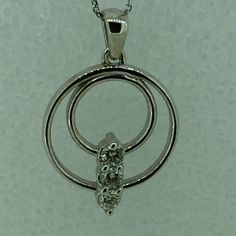 "14kt White Gold Lady's Diamond Double Circle Necklace consisting of 3 full cut round brilliant diamonds .33ct total weight SI1 clarity, G color all prong set in a double \"Circle of Life\" pendant. The FREE 16\" solid link curb chain has a lobster claw clasp. The total pendant circle measures 3/4\". This item would Retail for $1,790.00" Single Cut Diamond White Round Necklace, Diamond White Single Cut Round Diamond Necklace, White Gold Diamond Necklace With Round Pendant Accents, Three Stone Round Diamond Necklace, Anniversary Diamond Necklace With Round Prong Setting, Round Cut Diamond Necklace With Accents For Anniversary, Three Stone Cubic Zirconia Diamond Necklace, Anniversary Round Cut Diamond Necklace With Accents, Diamond Three Stone Round Cut Necklace