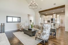 a living room filled with furniture and a chandelier hanging over the top of it