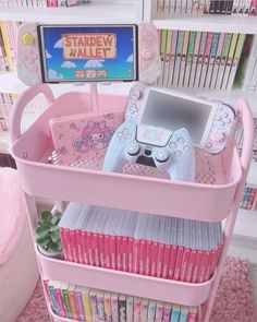 there is a pink toy shelf with books and video game equipment in the bins