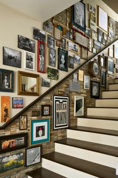 a staircase with many framed photos on the wall and pictures on the wall above it