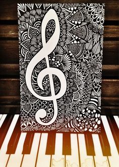 a music note is sitting on top of a piano keyboard and it's black and white