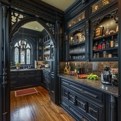 an ornate kitchen with wood floors and black cabinets