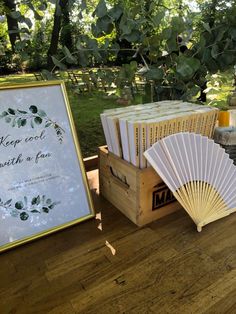 a wooden table topped with lots of books next to a sign and a fan on top of it